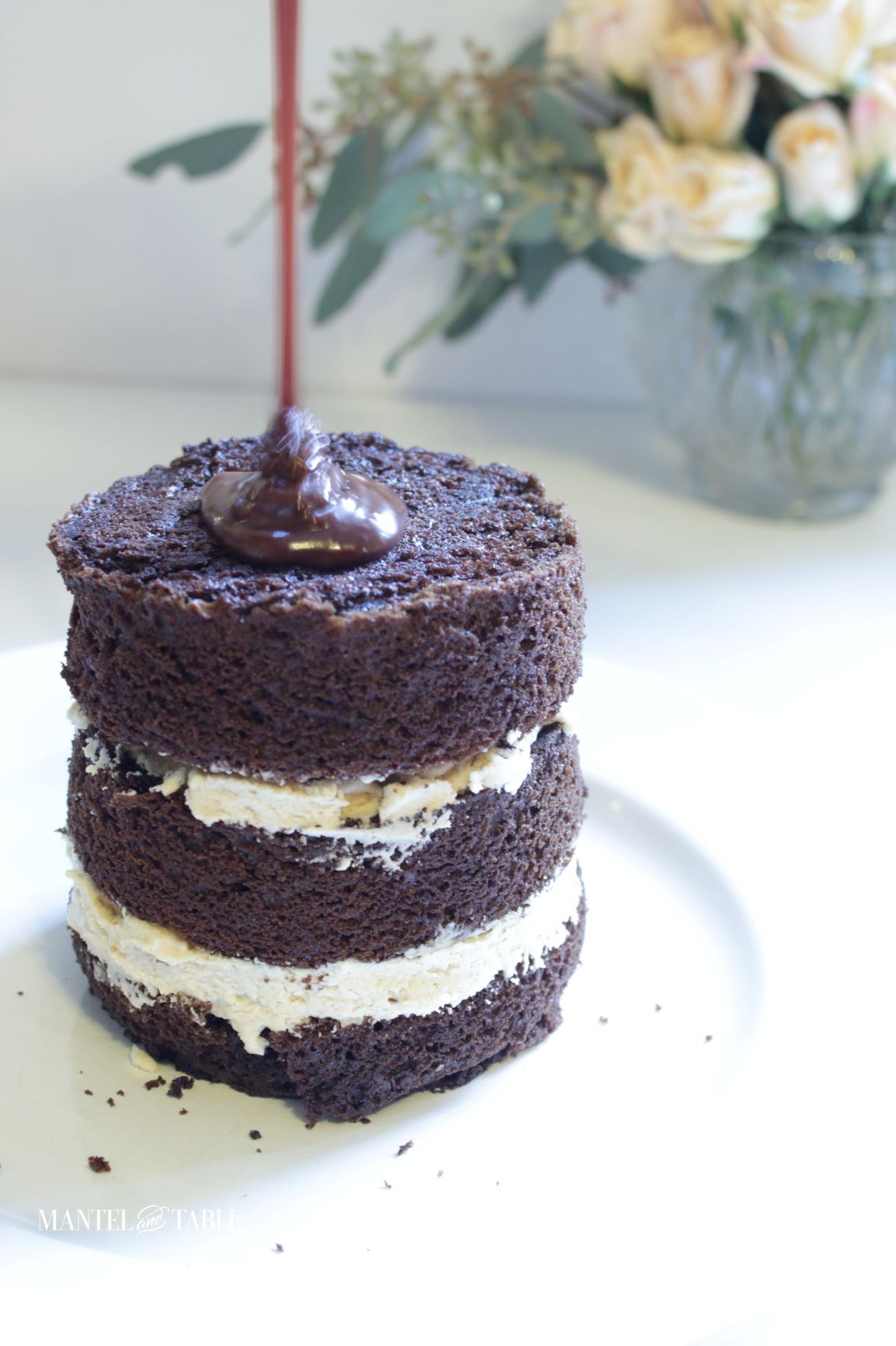 Chocolate ganache being poured onto cake layers