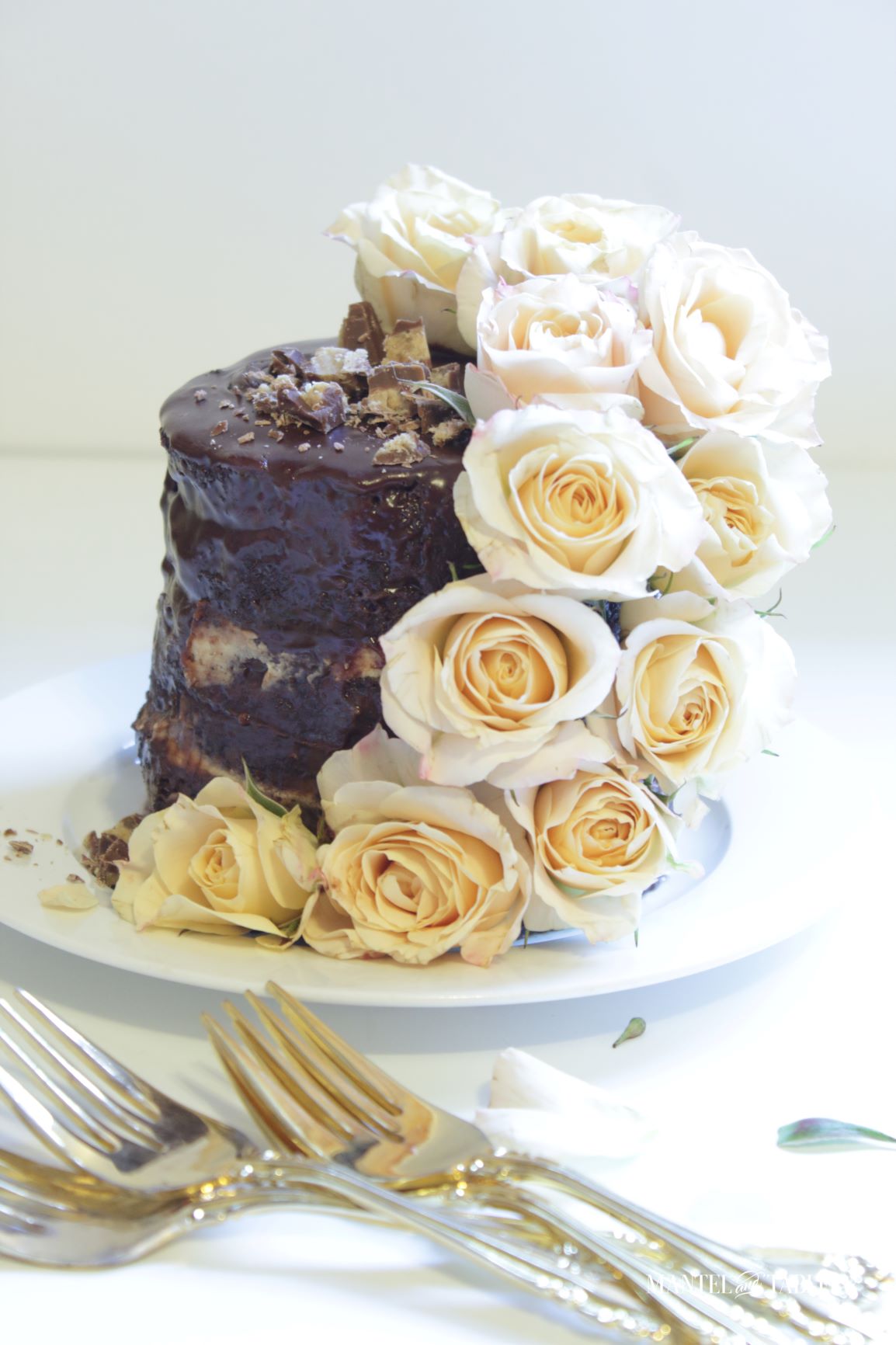 A tiny chocolate cake with cascade of creamy mocha colored roses