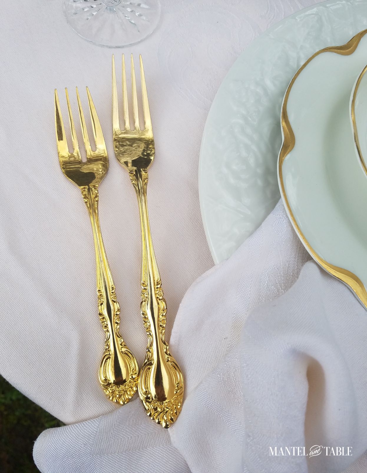 Gold forks beside plates on table