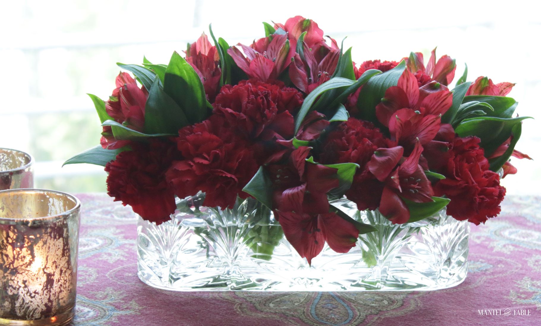Cozy tablescape ~ closeup of red flowers in crystal vase
