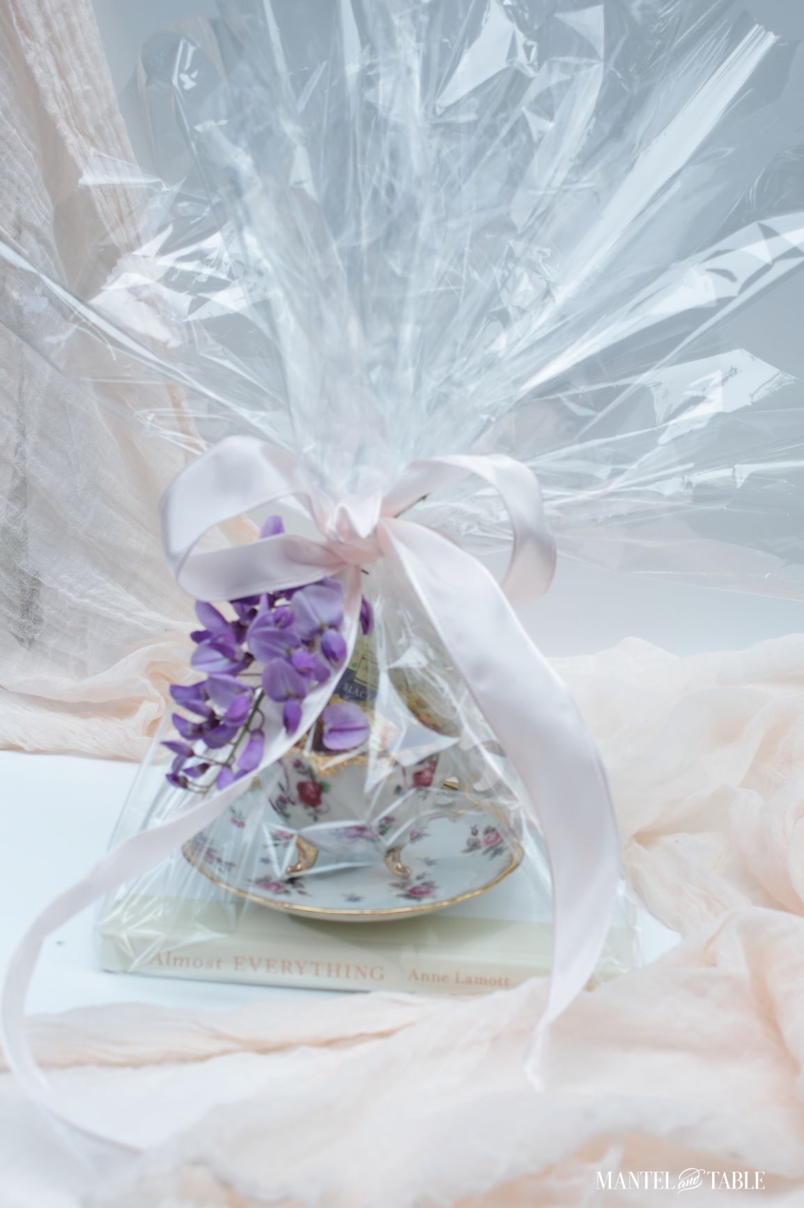 7 Teacup gift ideas ~ teacup filled with chocolates and wrapped in clear cellophane with a pink bow & wisteria