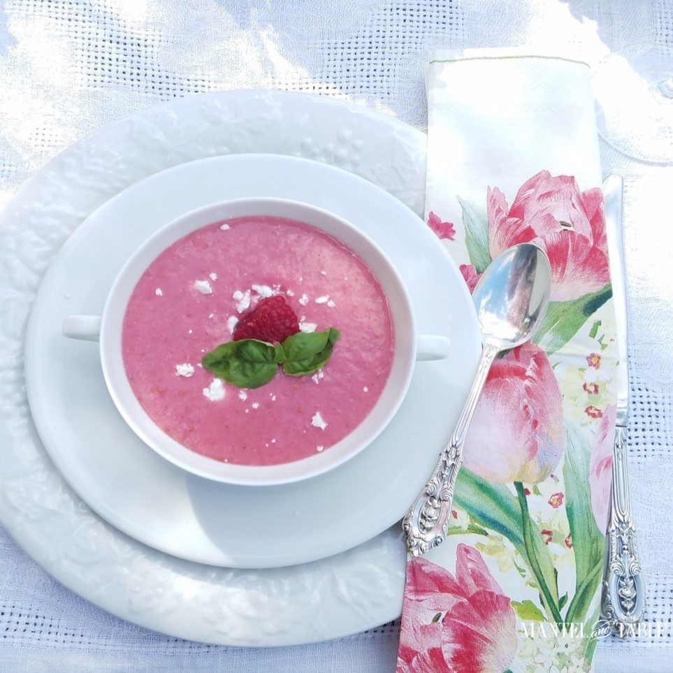 Bright pink chilled raspberry soup in a white bowl