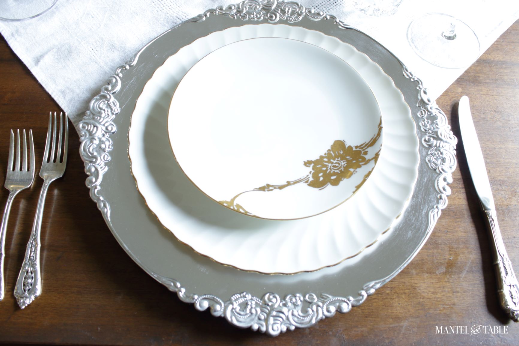 Silver and Gold Table Setting ~ view of plate stack and silverware on table