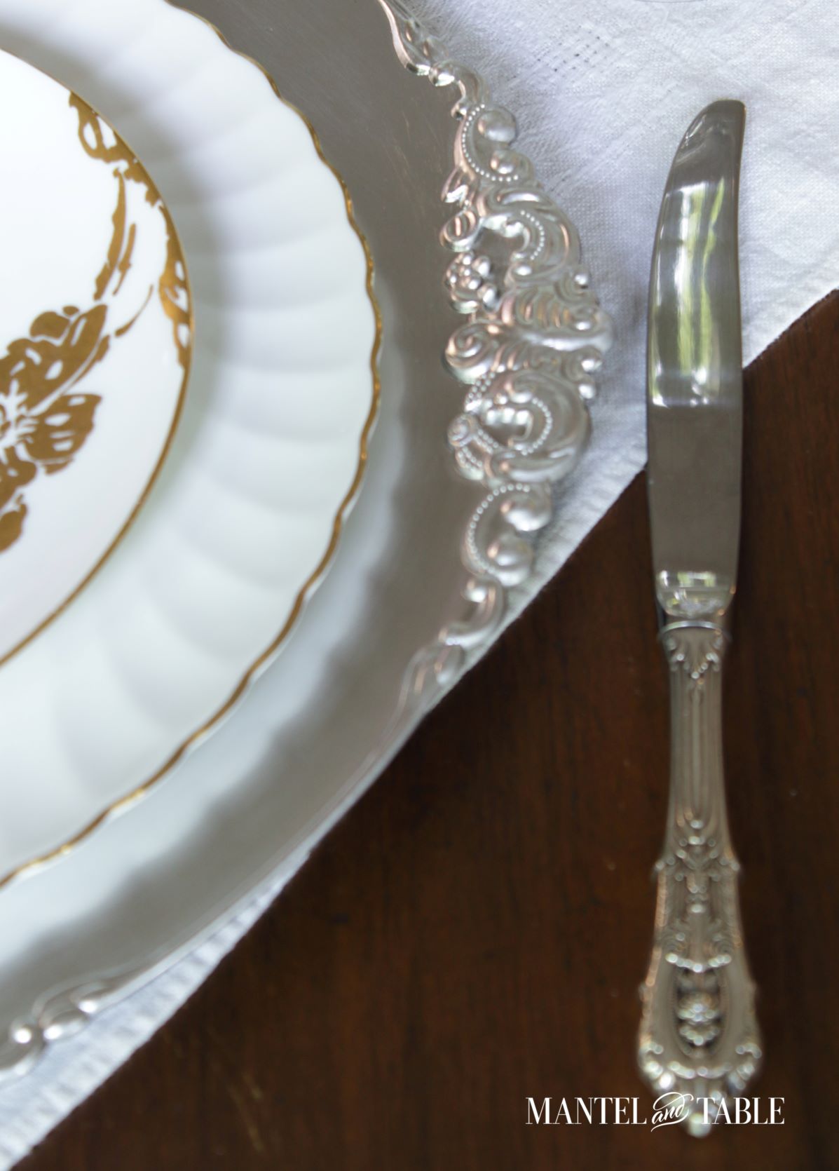 Silver and Gold Table Setting ~ closeup of plate stack and knife