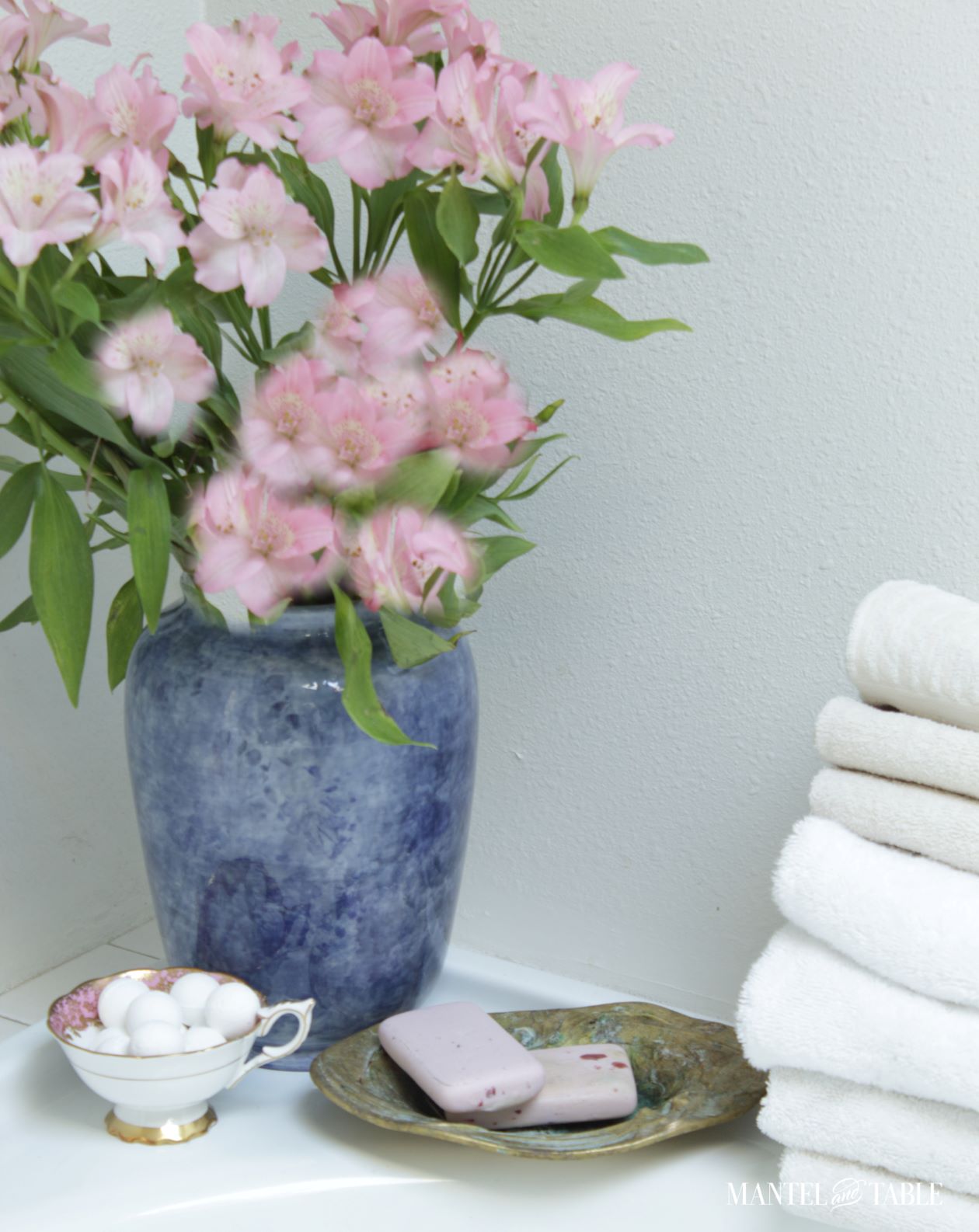 Bath balls in teacup on side of bathtub