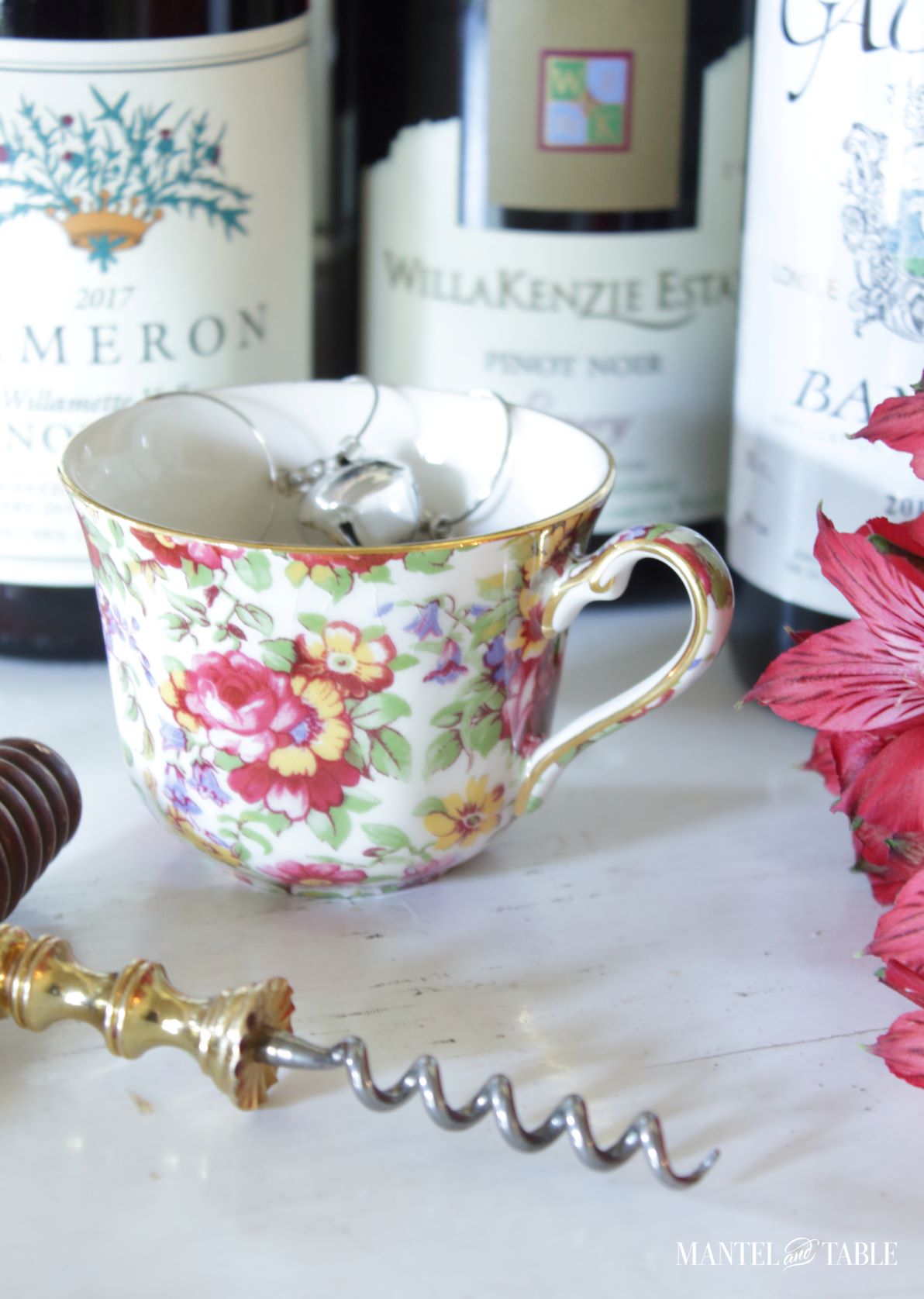 Wine charms in teacup with wine bottles