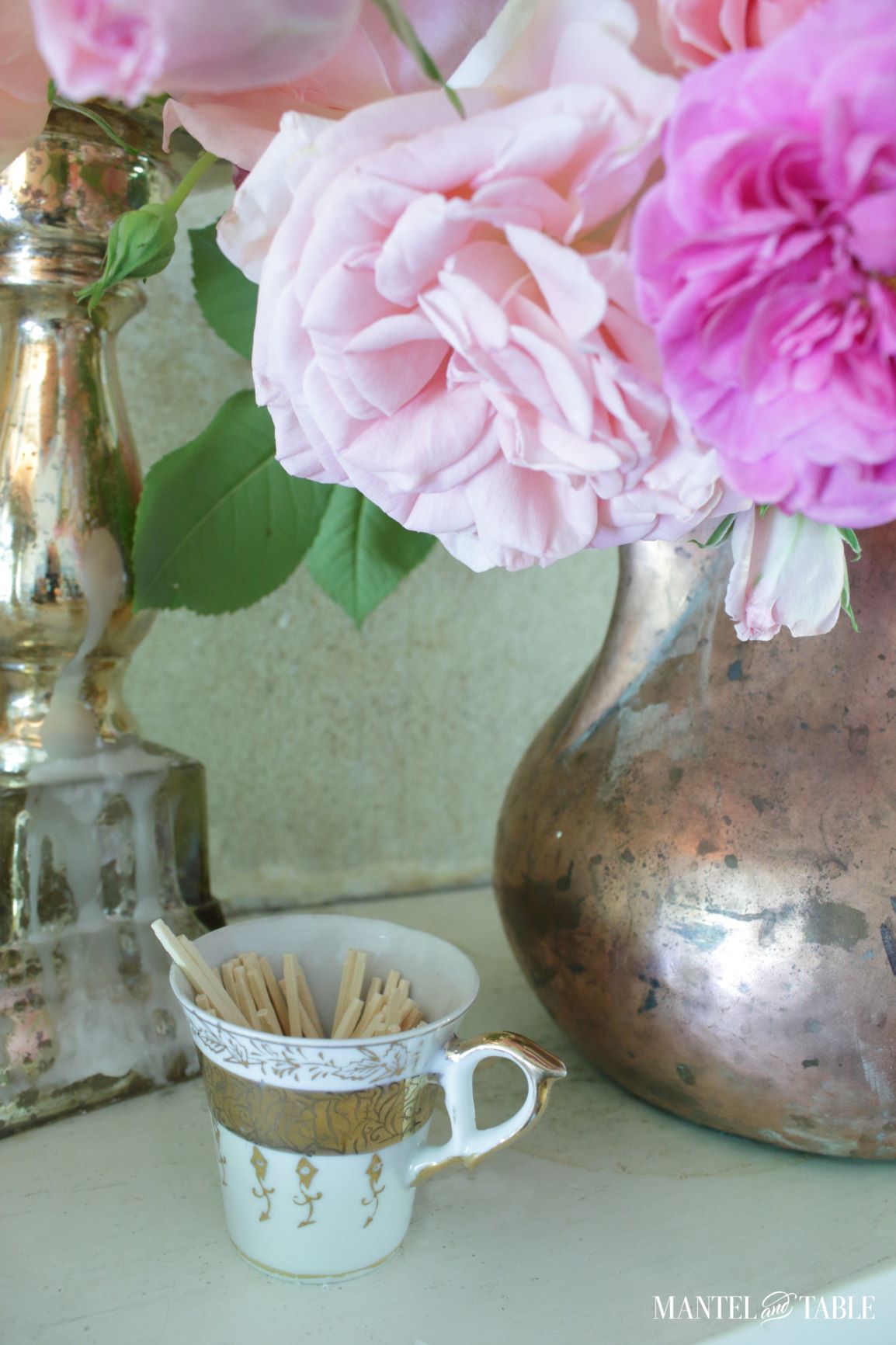 Gold & white teacup holding wooden matchsticks on the mantel