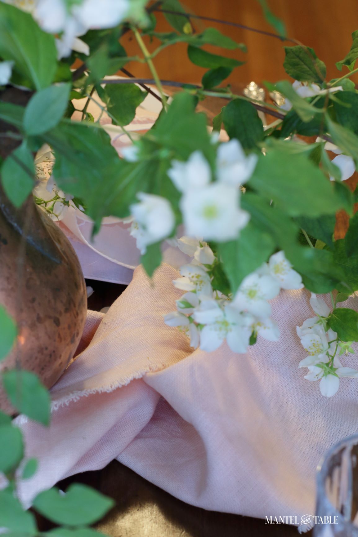 Blush table linens and white blossoms