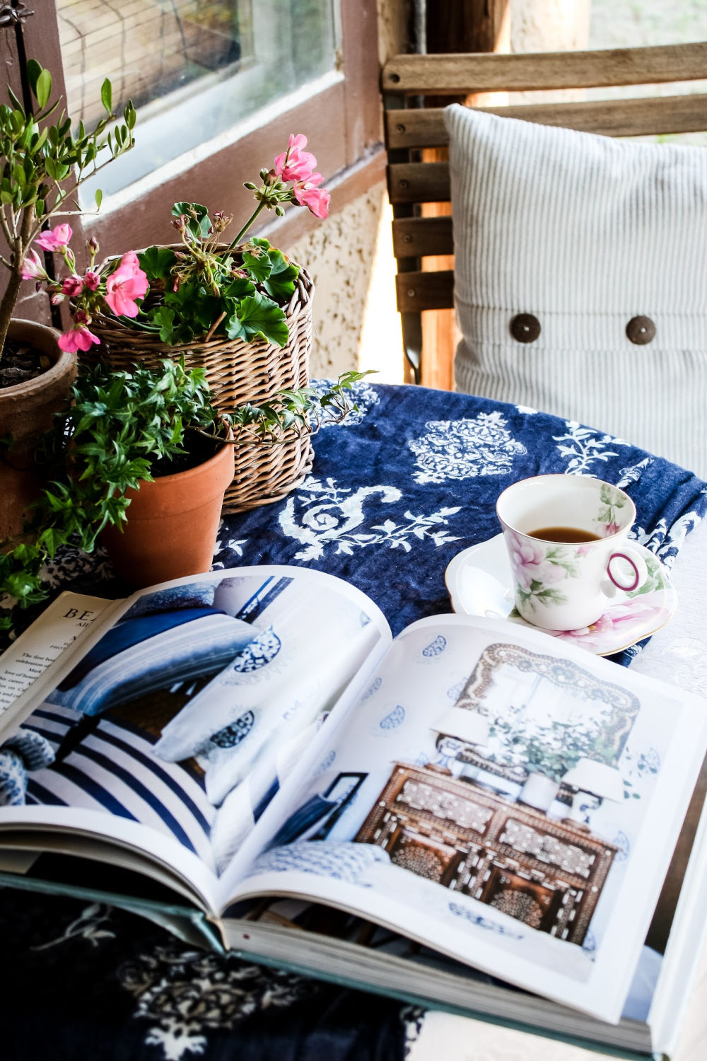 teacup on table with decorating book and flowers