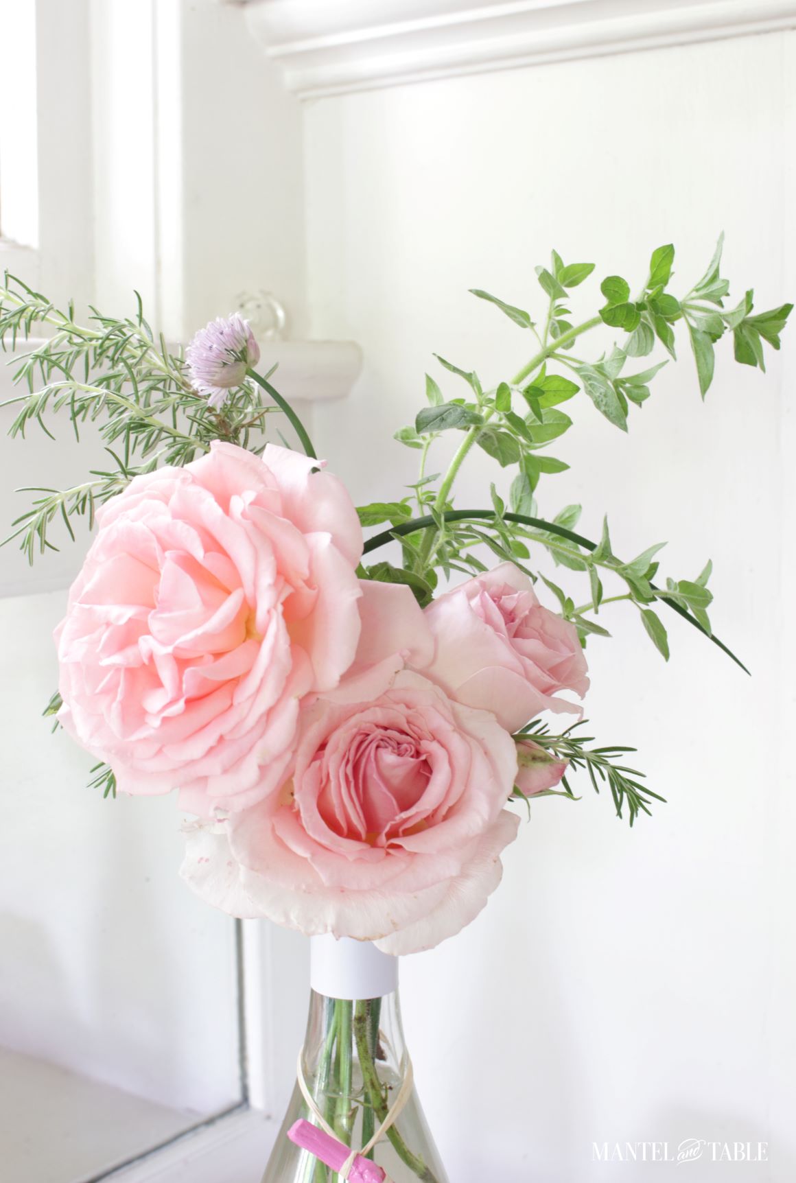 Herbs with pink roses in bottle