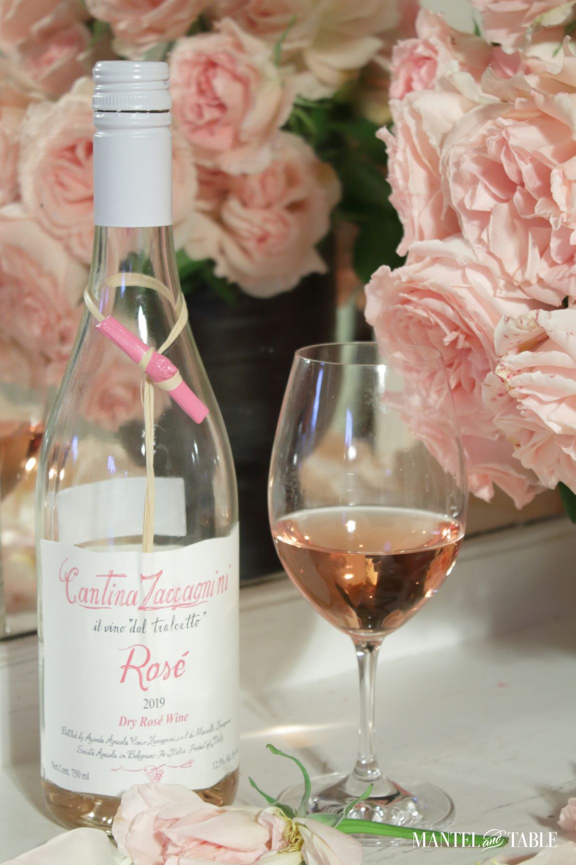 Glass of rosé and wine bottle with roses