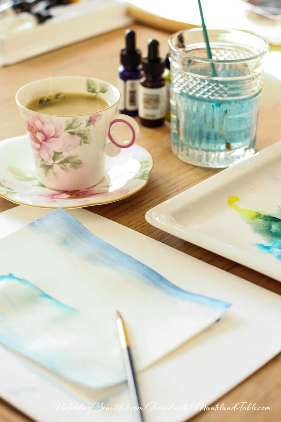 Teatime - teacup on a table with artist's paper and watercolors