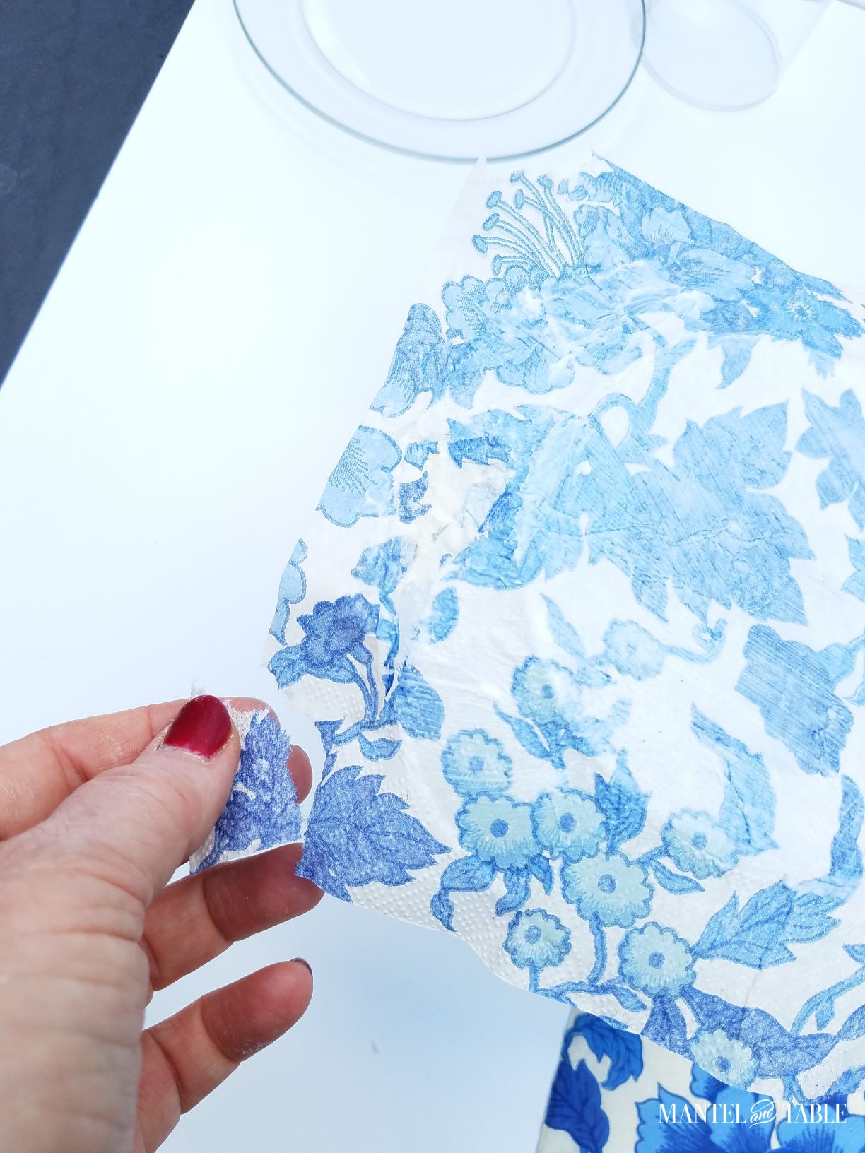Hand tearing off a piece of excess napkin on the DIY plate