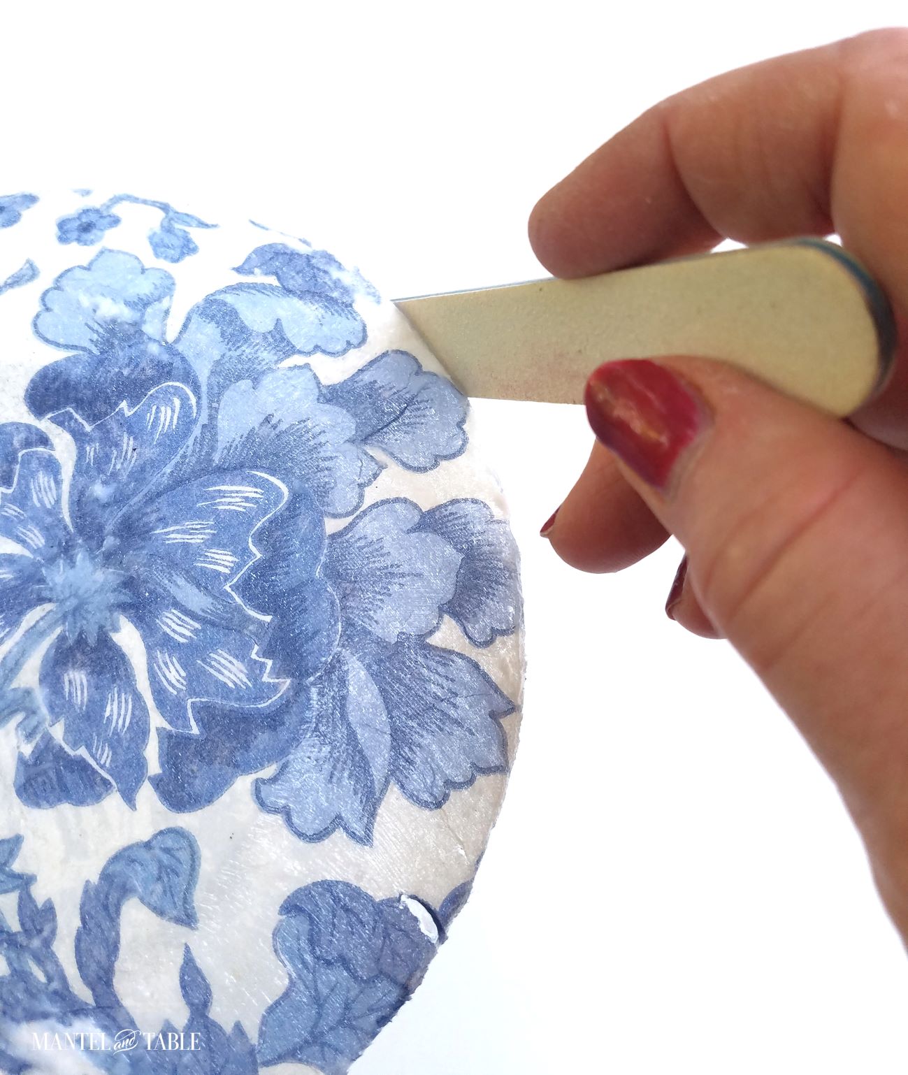 Filing the edge of the DIY plate with an emery board