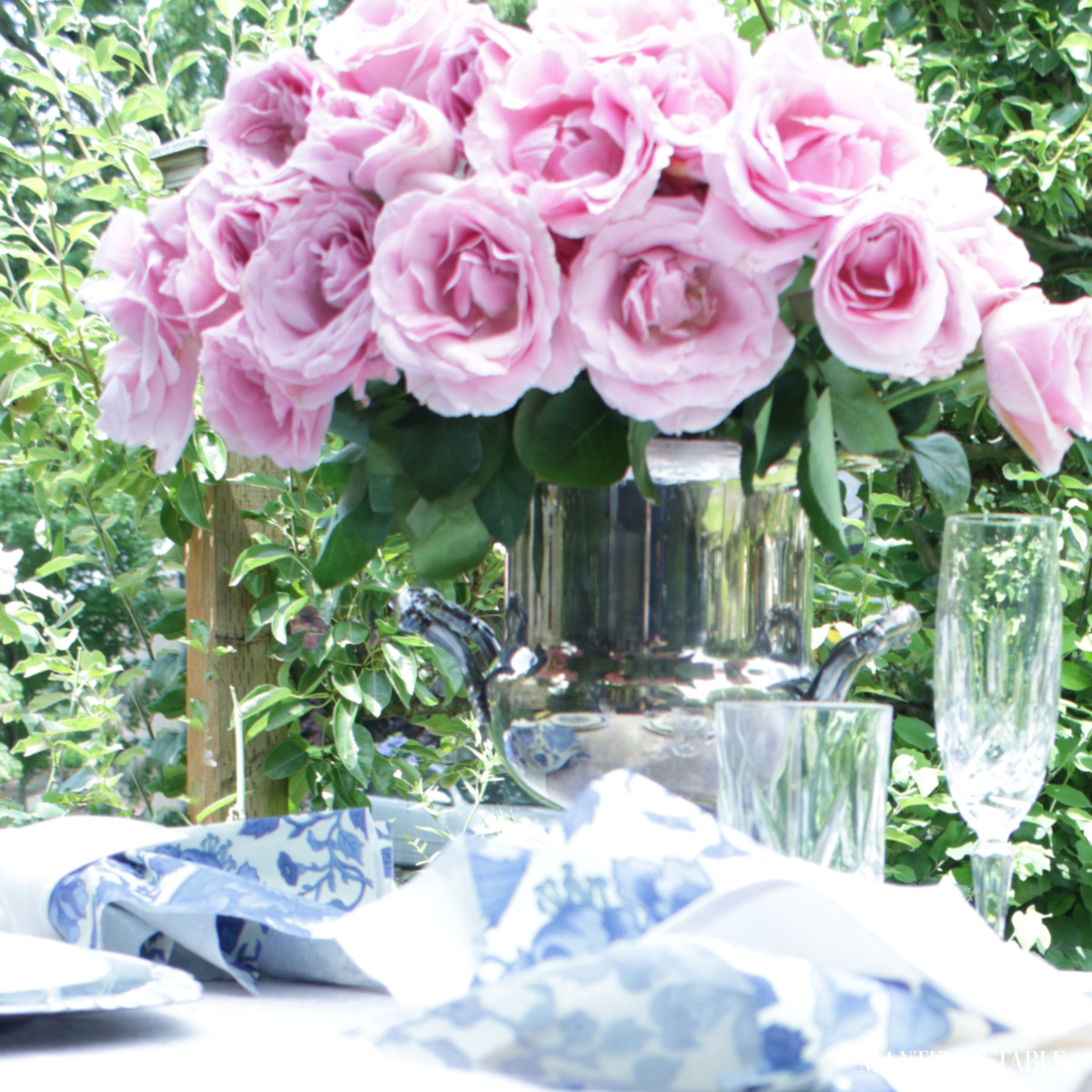 Pink roses in a silver wine bucket centerpiece
