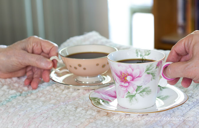 Two hands holding a teacup each - full of coffee