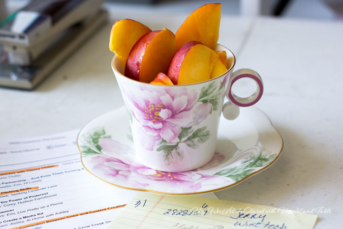 Pink flowered teacup holding nectarine slices