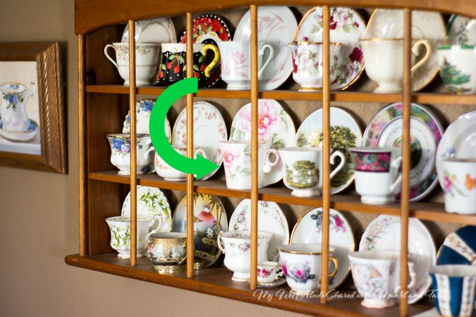 Teacups on a shelf in So Cal. Traveling Teacup marked with an arrow