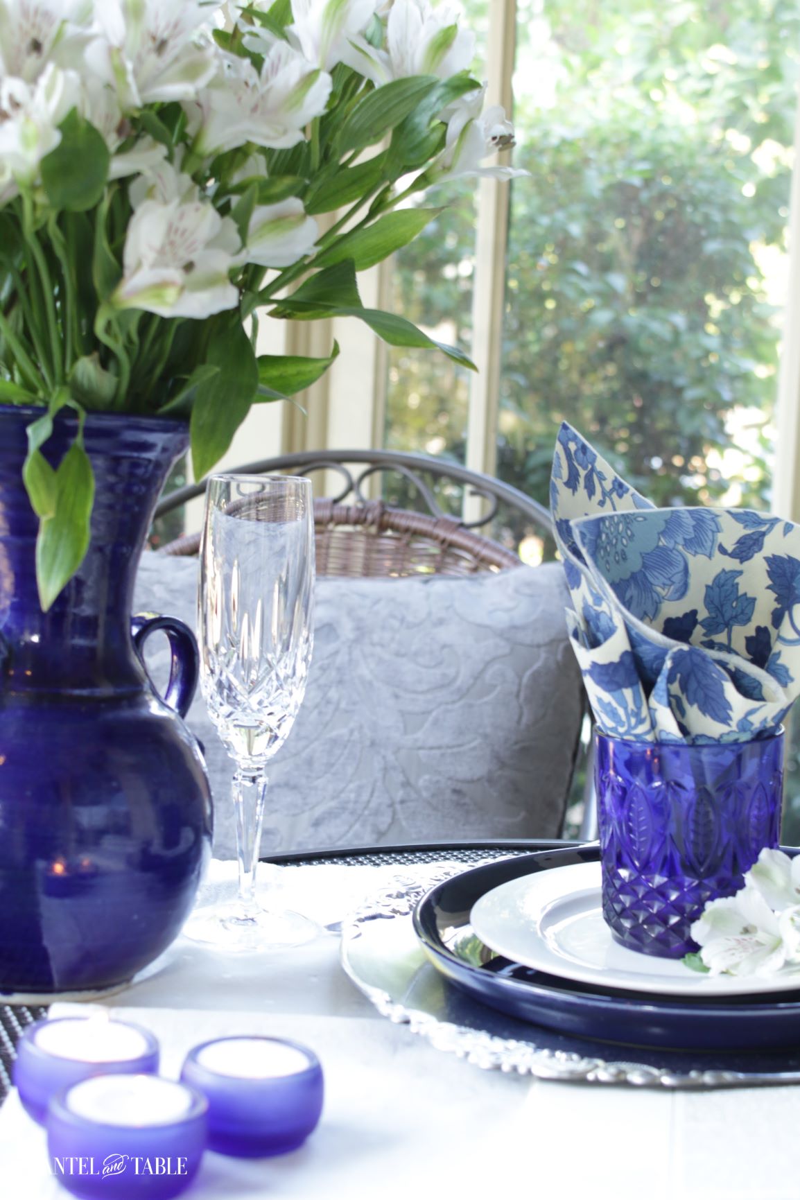 Blue and white tablescape with candles in the foreground