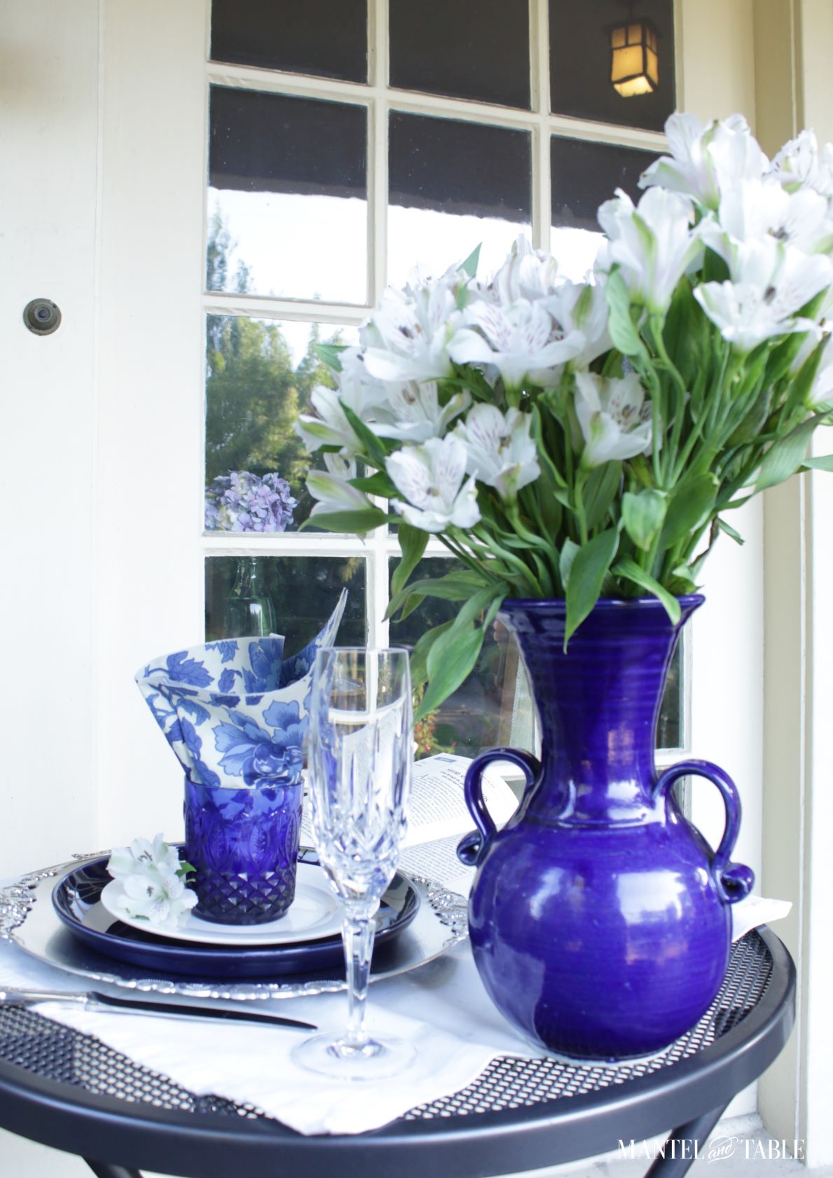 Blue and white tablescape side view with flower arrangement