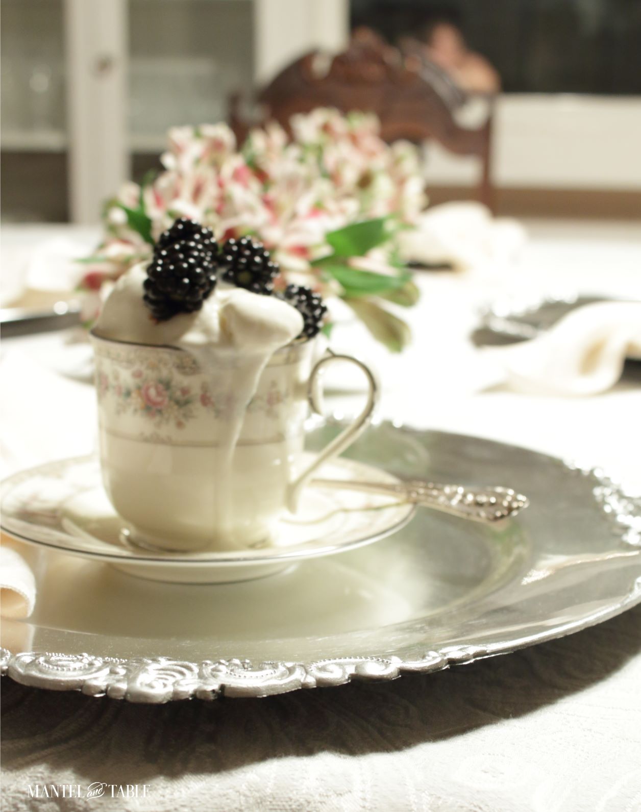 Closeup of ice cream melting over top of teacup on silver charger