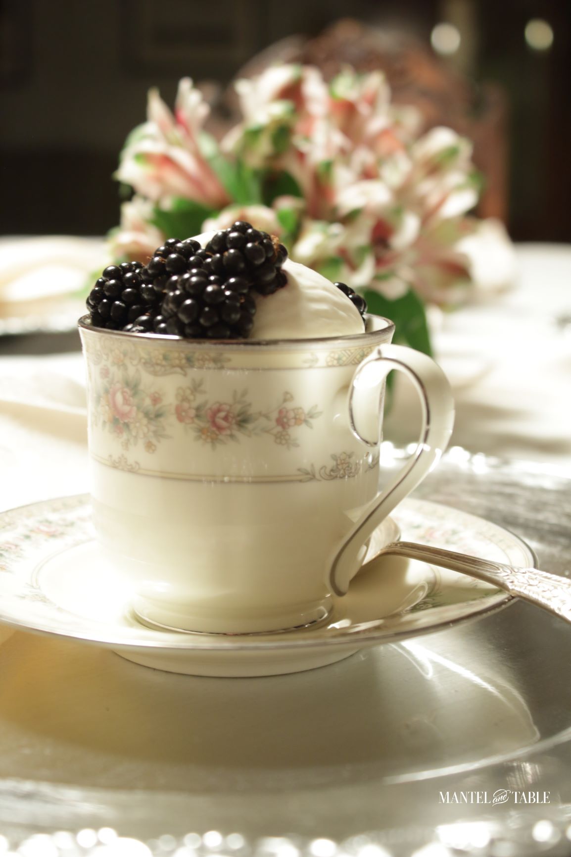 Closeup of a white & pink flowered teacup with ice cream & berries in it