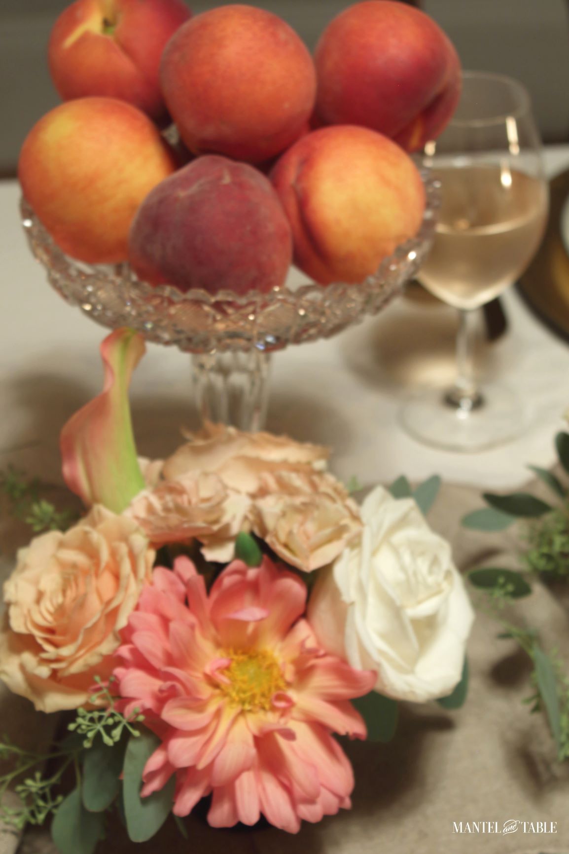 Crystal bowl of peaches on table