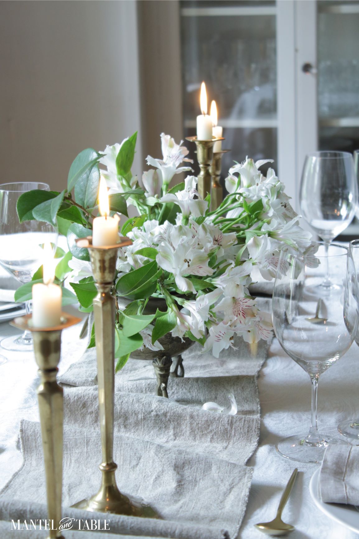 Linen table runner on table with white flowers, candles