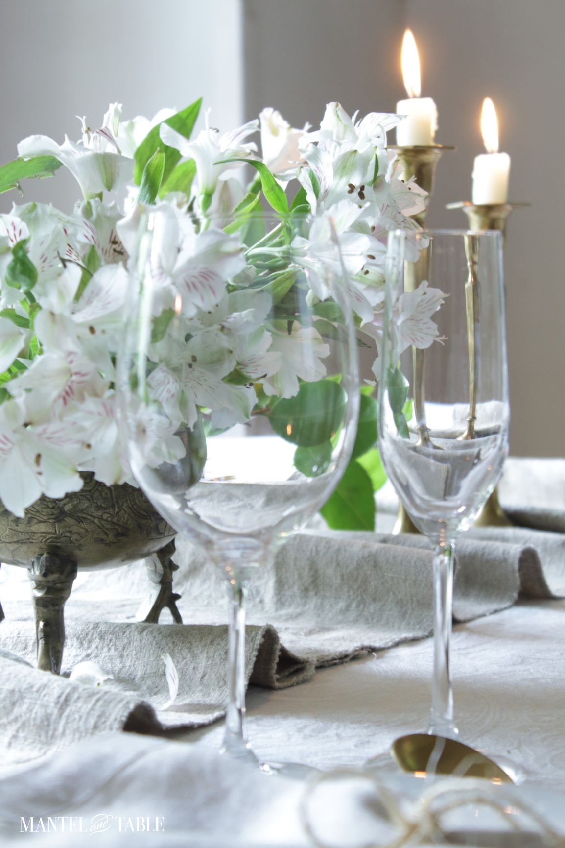 View of flowers on table runner seen through wine galsses