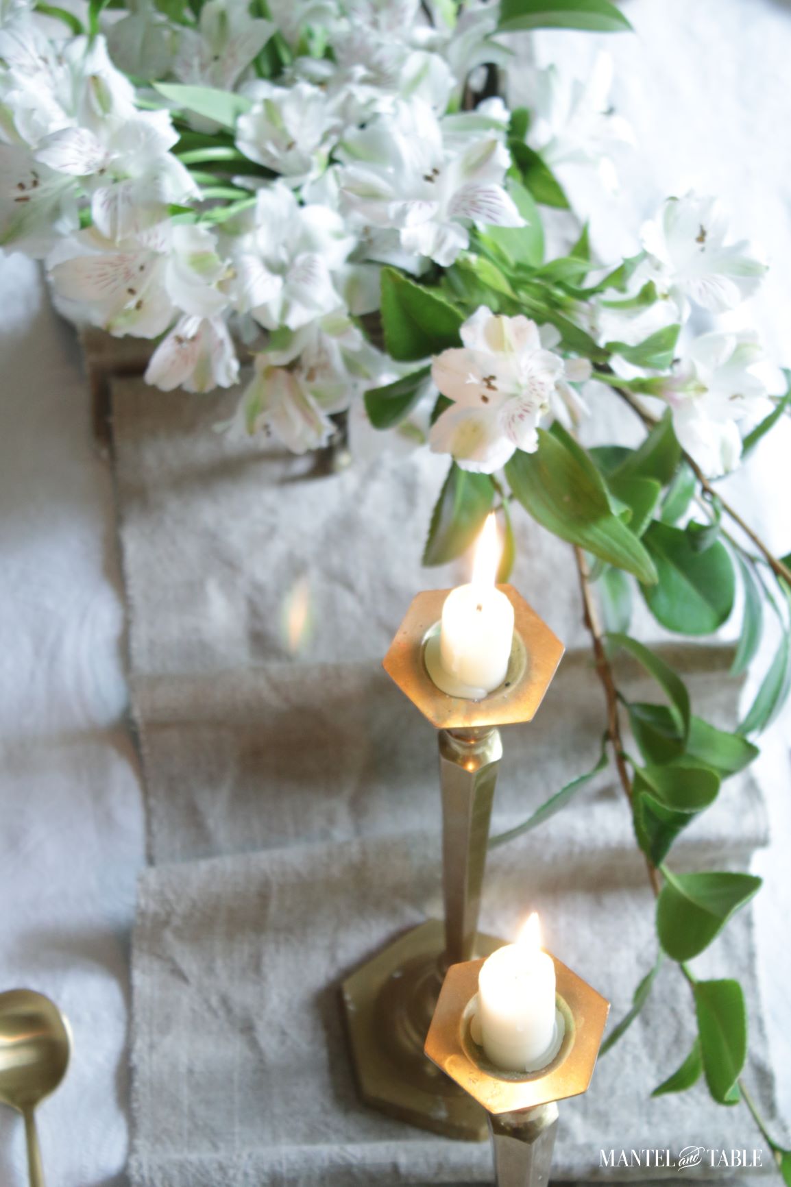 Top view of table runner and lighted candles, flowers