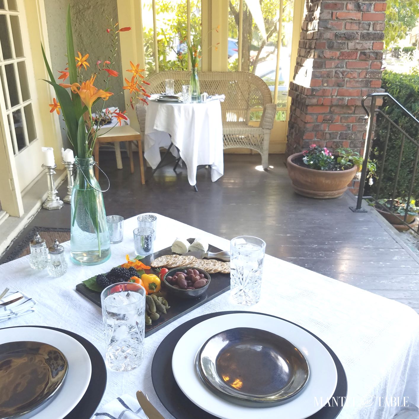 Top 10 Favorites - Two white linen draped and set dinner tables at opposite ends of a porch in evening sun