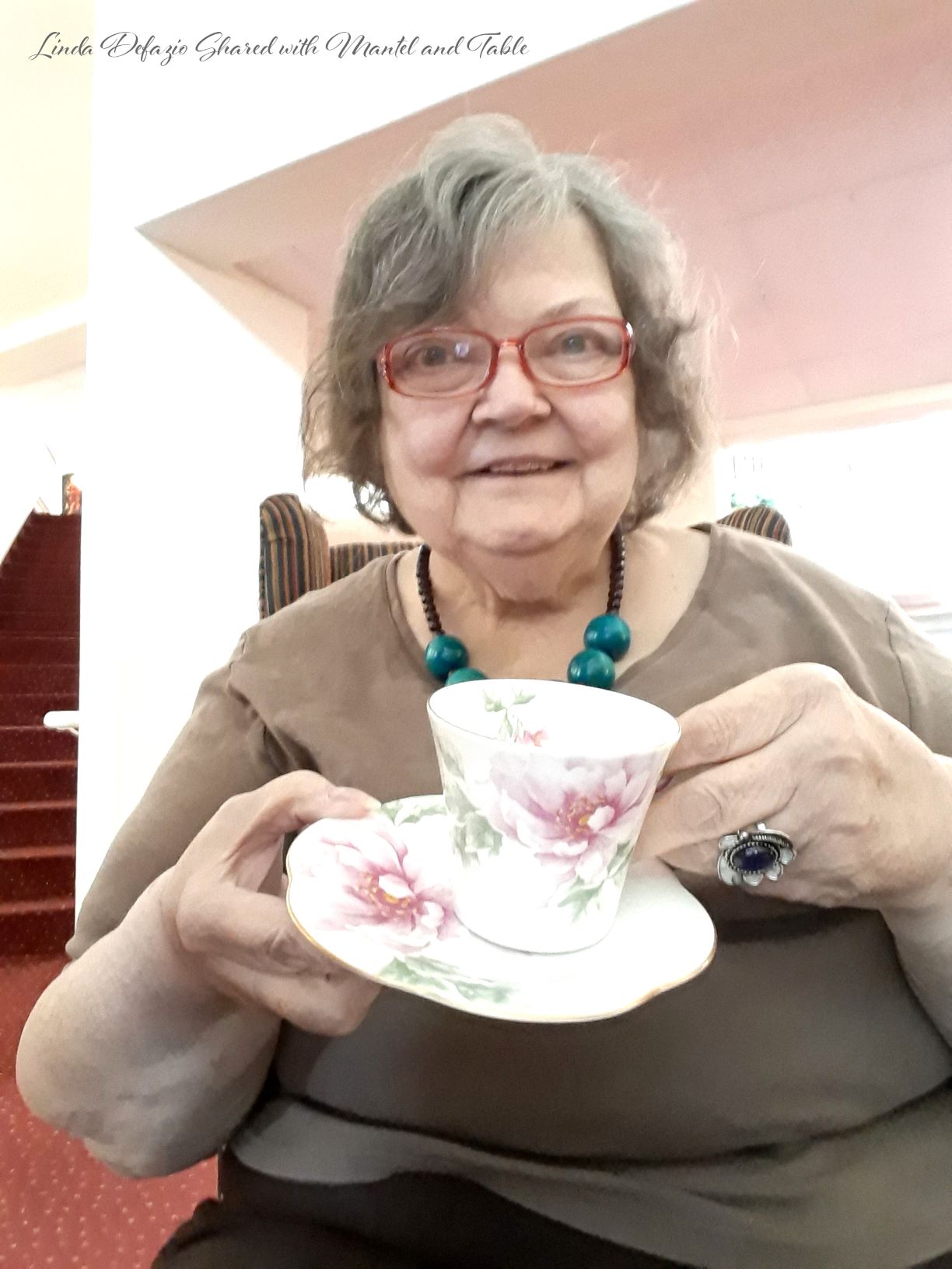 Woman displaying a teacup and saucer at Somerset Lodge