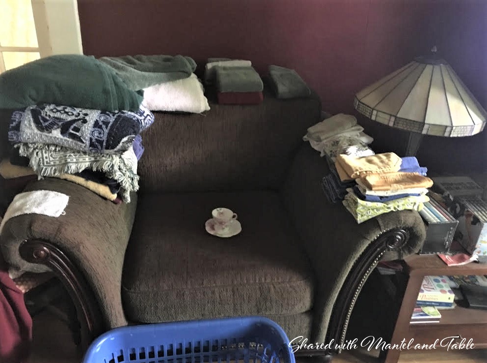 Teacup on an overstuffed chair with folder laundry