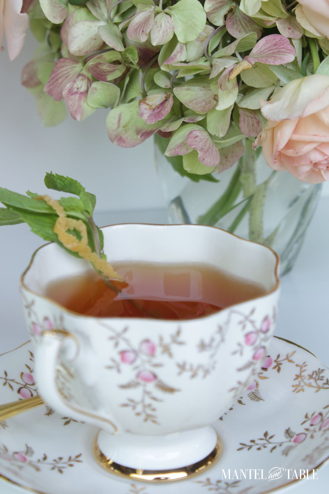 CLoseup of Cocktail in a teacup with mint & grapefruit rind garnish