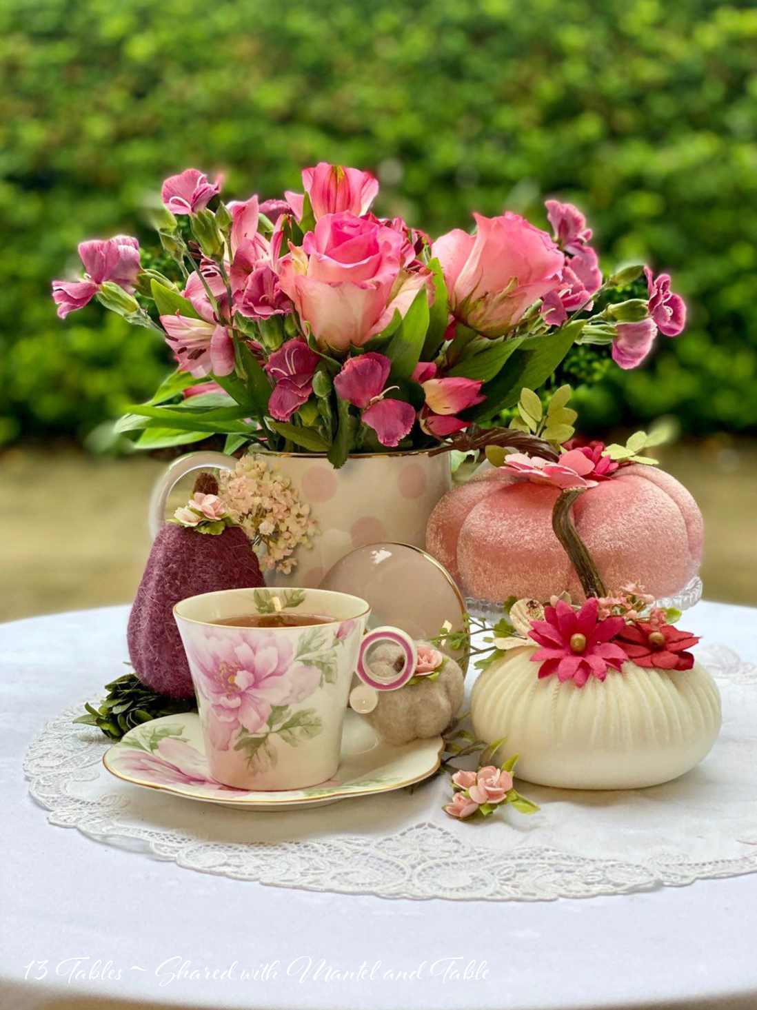 Side view of teacup and velvet pumpkins on outdoor table. flowers