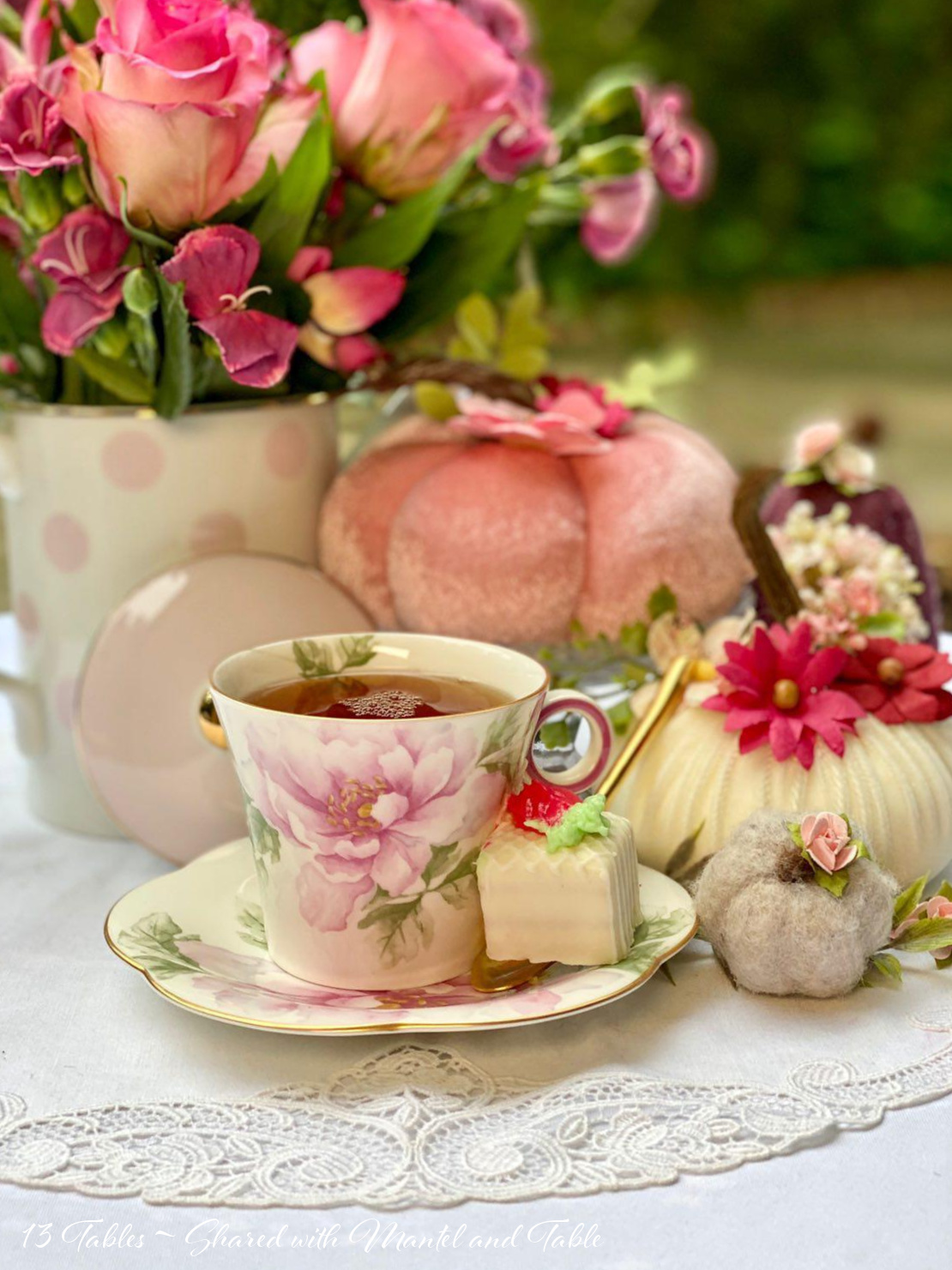 Teacup with tea, and small white cake on saucer