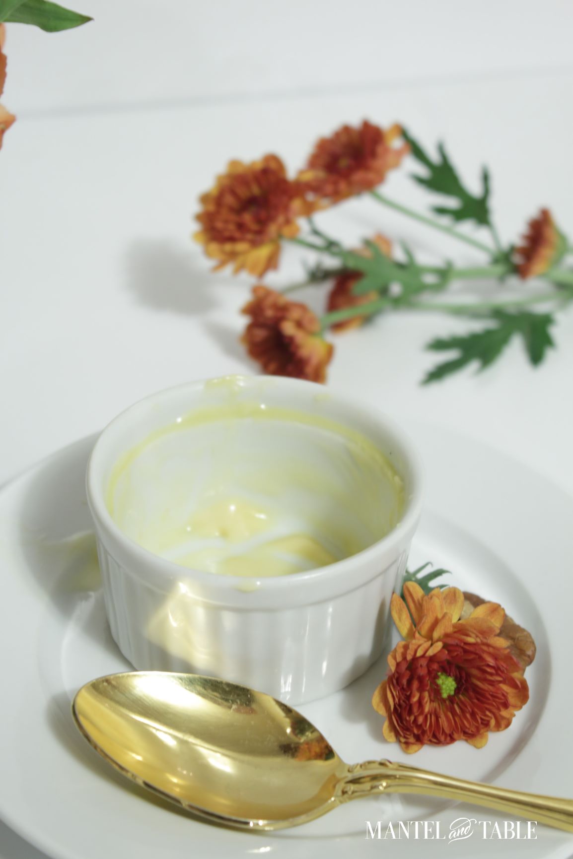 Empty Pumpkin pot de creme ramekin on plate with flower and spoon