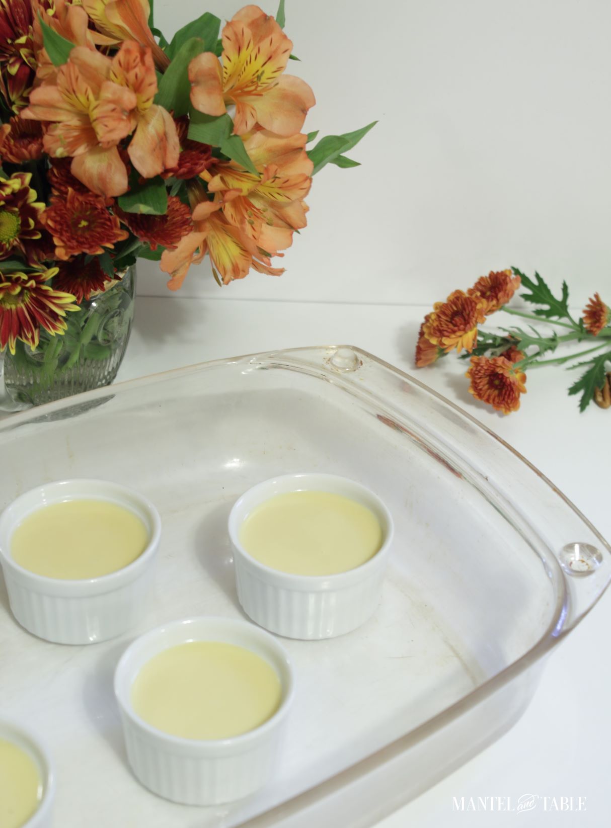 Ramekins in baking dish filled with Pumpkin pot de creme mixture