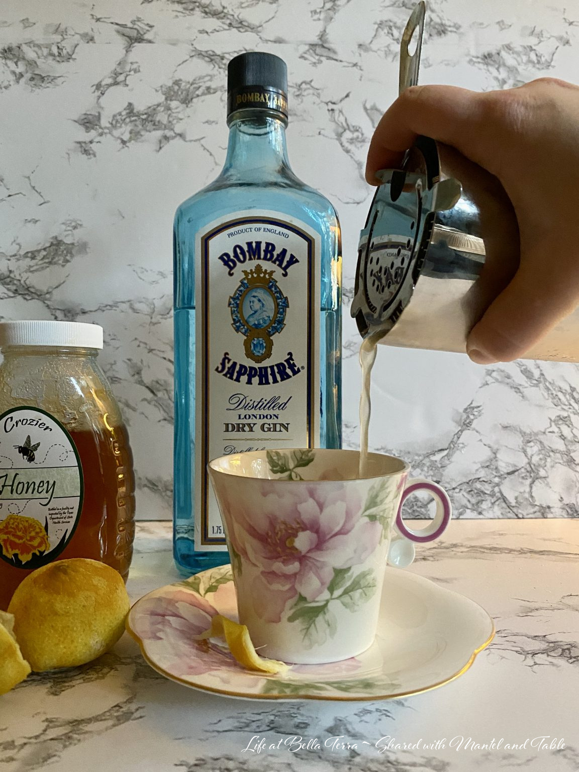 Pouring cocktail from shaker into teacup
