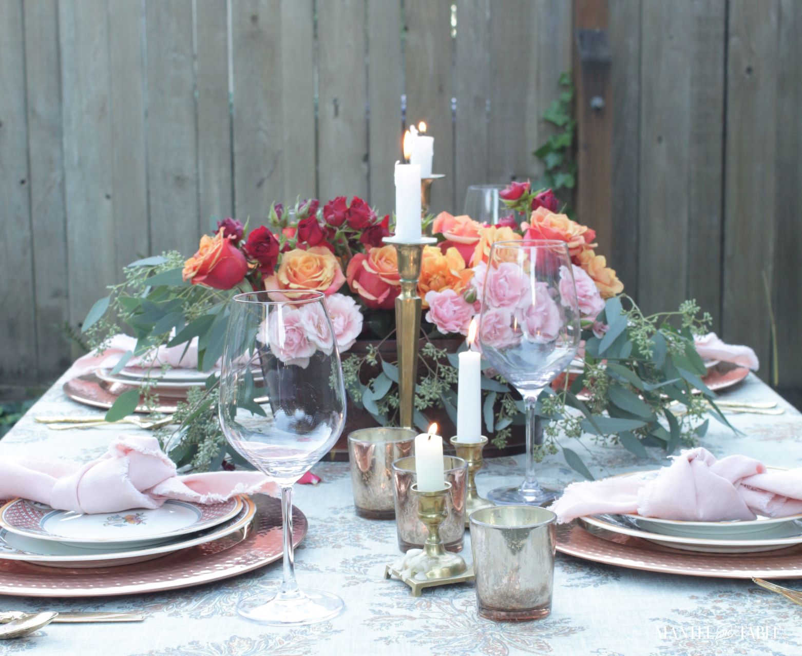 Beautiful table setting with pink, orange, and red flower centerpiece