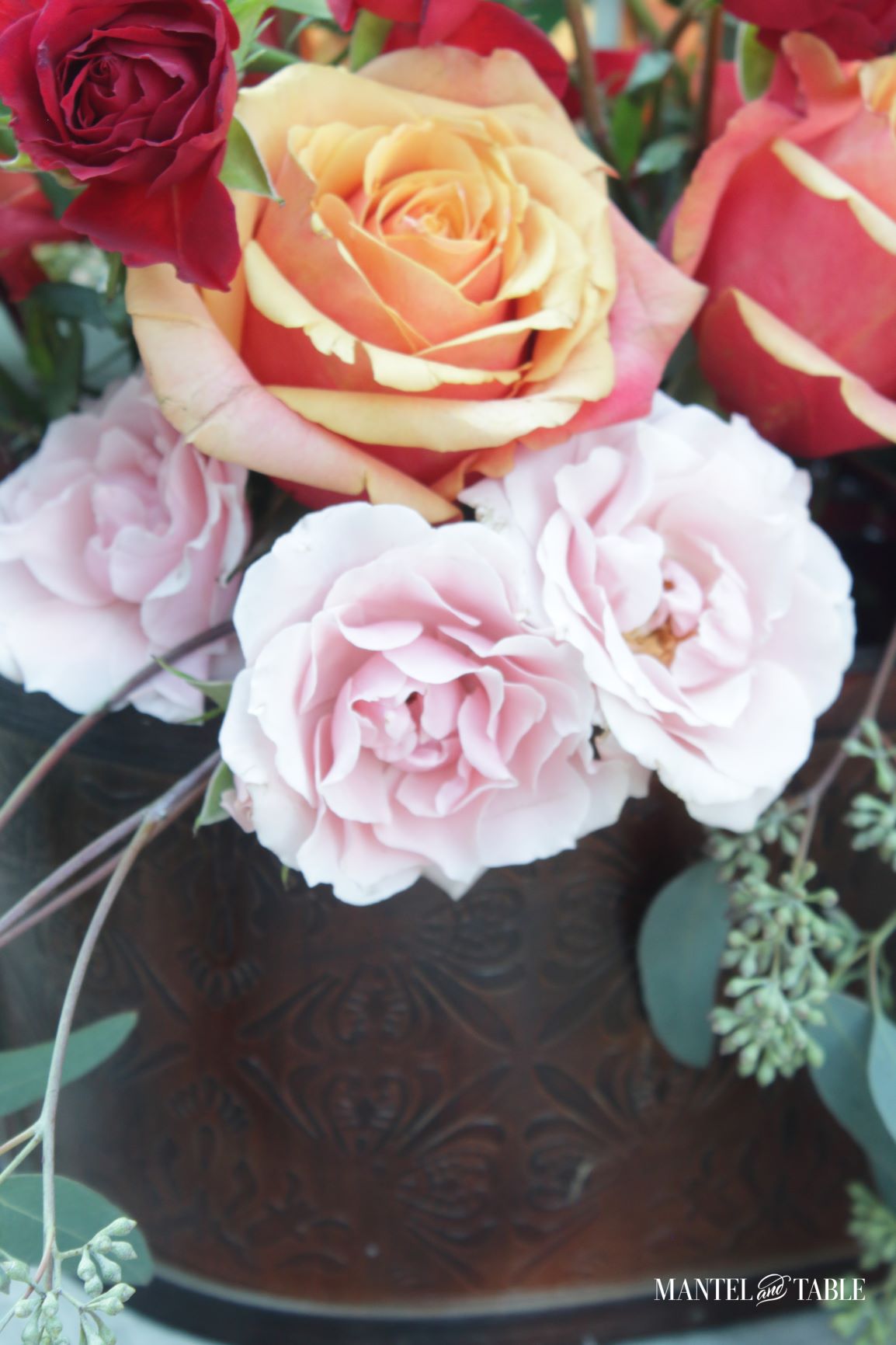 Flower arrangement in brown tub-shaped bucket