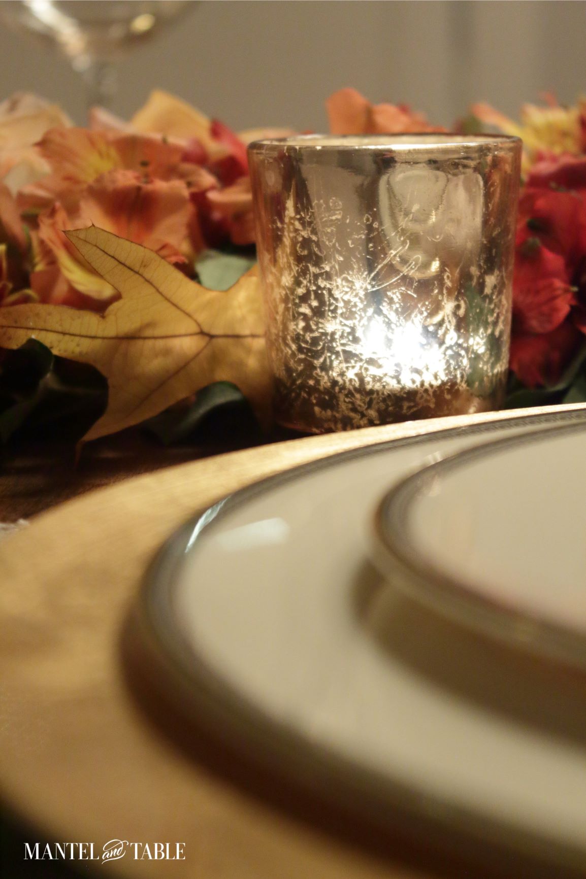 closeup of gold votive candle and fall leaves