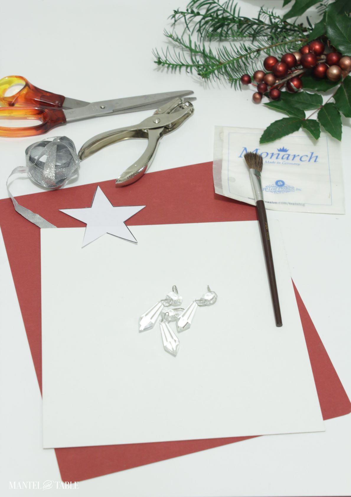 All the supplies for the star on a white surface with holly and berries