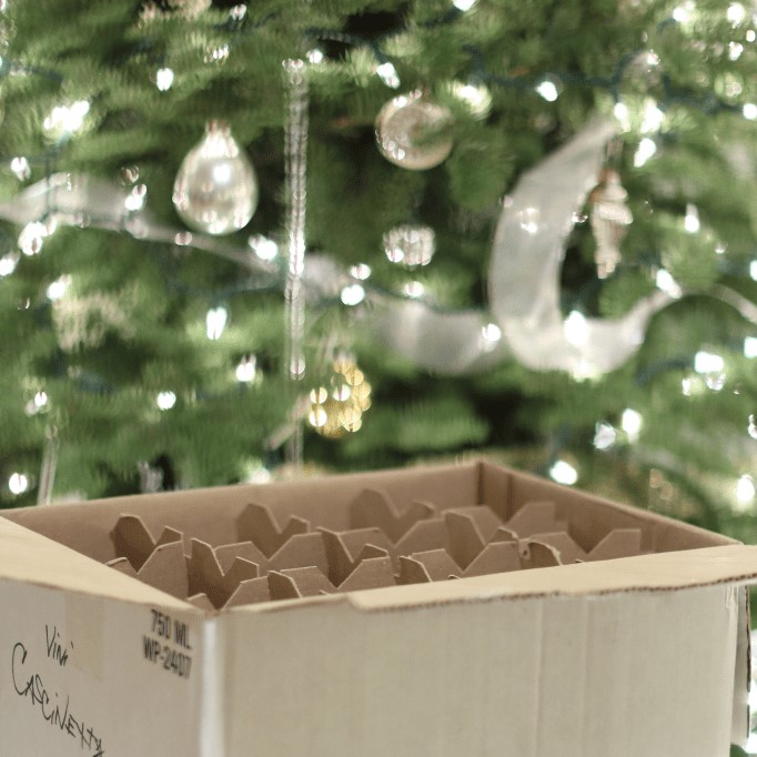 Top 10 Favorites - Christmas ornament storage cardboard box in front of silver decorated tree