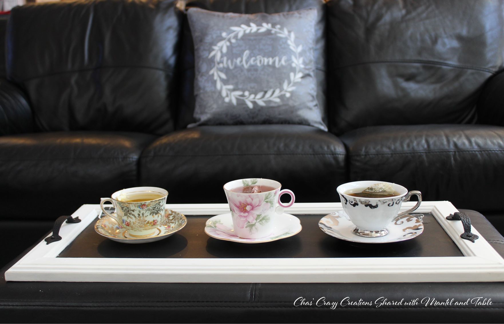 Teacup Adventure - three cups on a tray in front of black leather couch