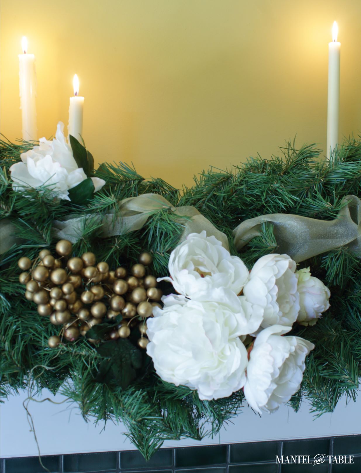 Closeup of white peonies and gold berries in pine garland