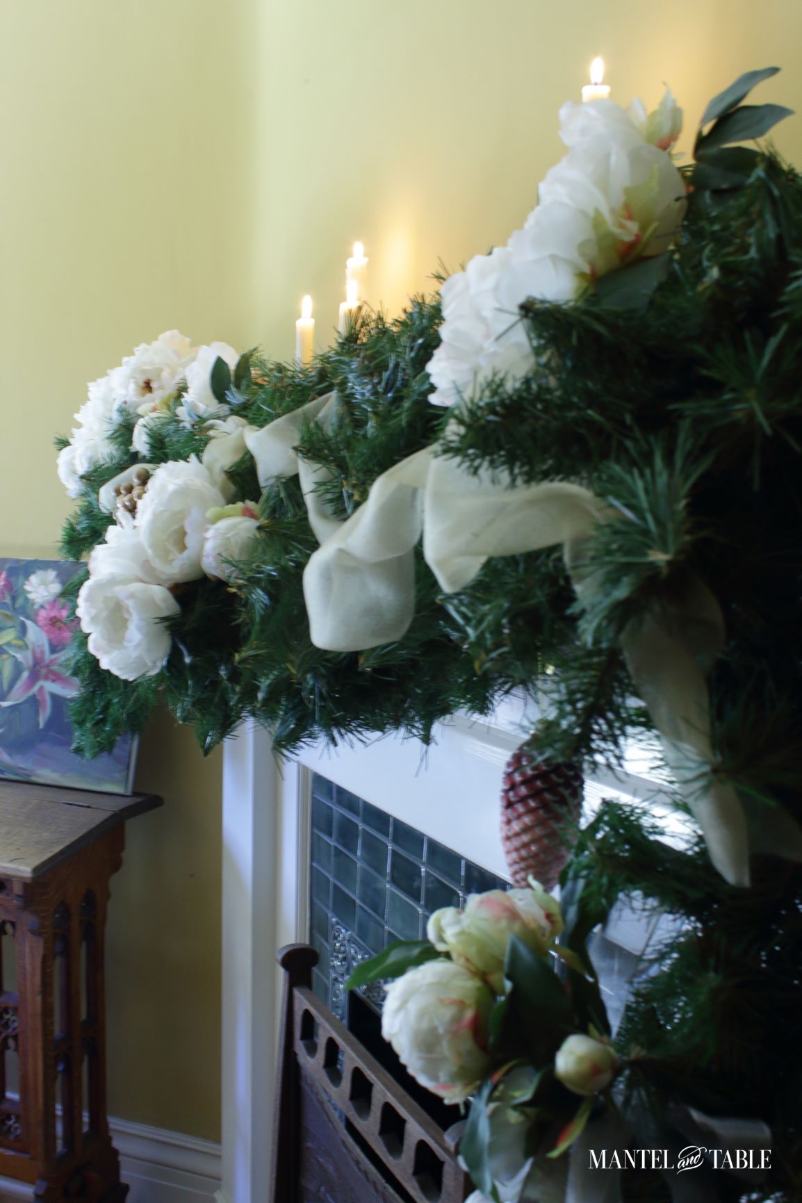 Closeup of white peony mantel with evergreens