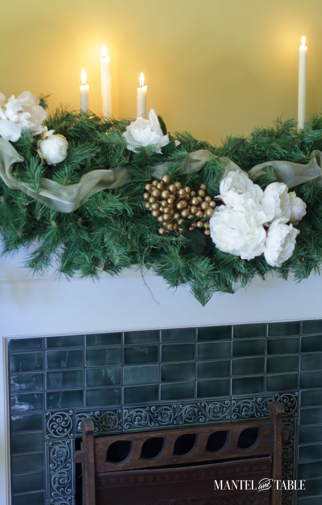 Closeup of gold berries and white peonies in mantel garland