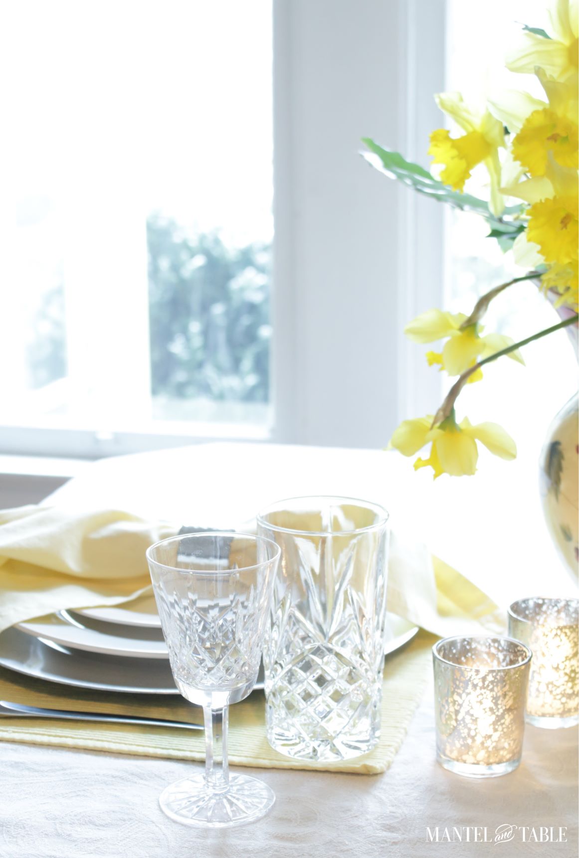 Closeup of crystal glasses and flowers in the daffodil table setting
