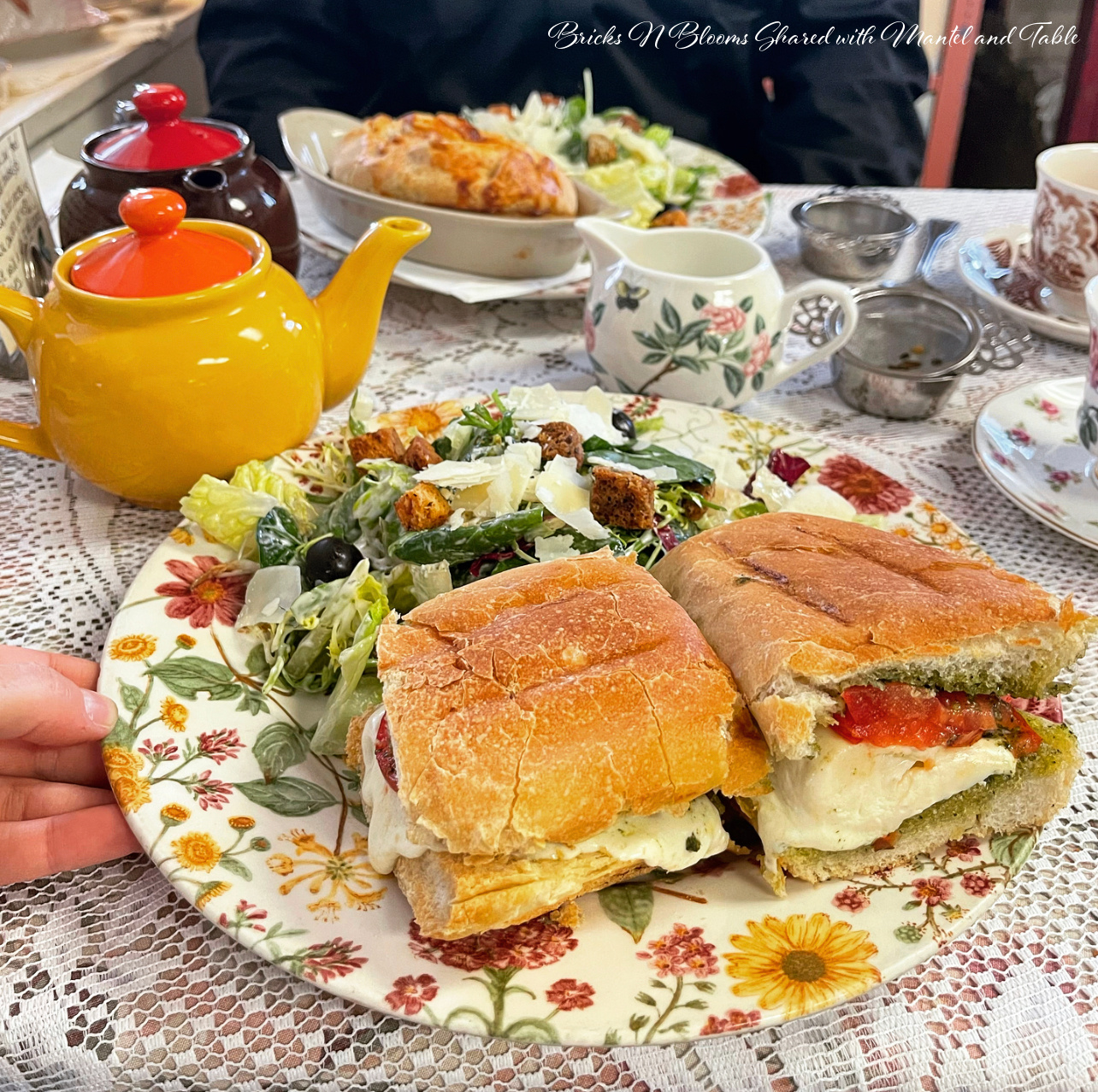 A flowered plate with sandwich and salad at high tea